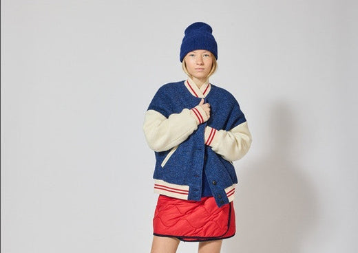 frau in blau weiß roter college jacke