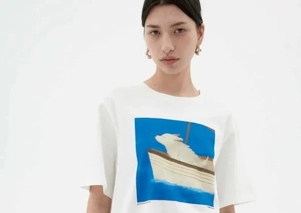 frau mit einem blau weißen T-shirt, motiv: ein Hund auf einem Segelboot streckt seine schnauze in den wind